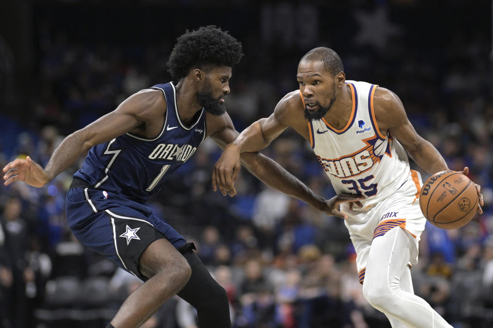 Phoenix Suns forward Kevin Durant (35) drives to the basket as Orlando Magic forward Jonathan Isaac (1) defends during the first half of an NBA basketball game, Sunday, Jan. 28, 2024, in Orlando, Fla. (AP Photo/Phelan M. Ebenhack)