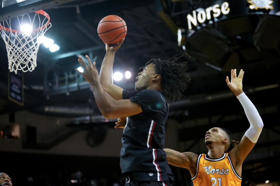 Cincinnati Bearcats forward Kalu Ezikpe (1) rises to the basket as Northern Kentucky Norse forward Chris Brandon (21) defends in the first half during a college basketball game, Wednesday, Nov. 16, 2022, at Truist Arena in Highland Heights, Ky.