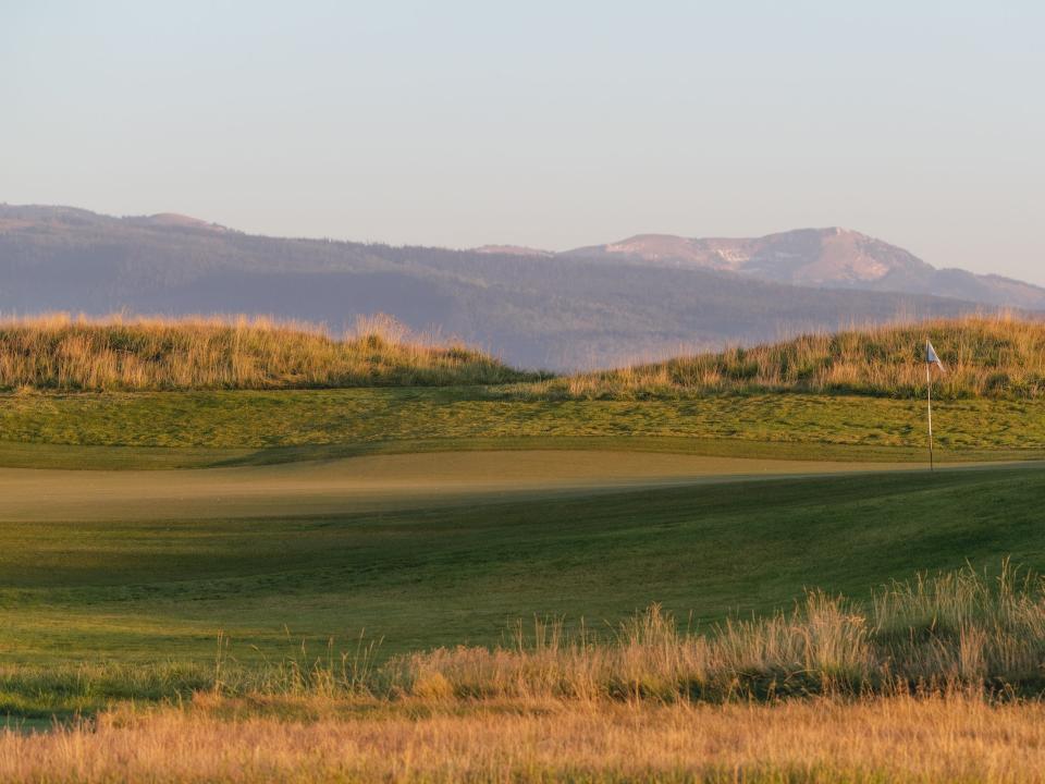A golf course with a mountainous landscape in the background.