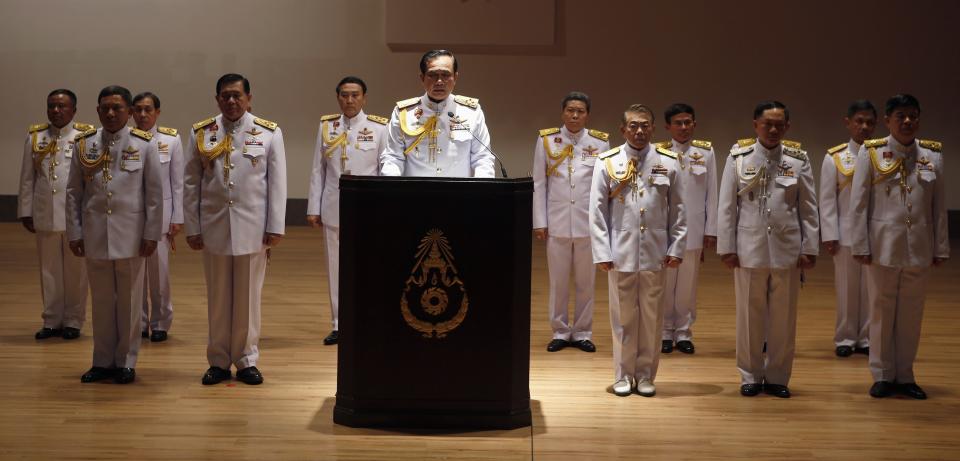 Thai Army chief General Prayuth Chan-ocha (C) is accompanied by his officers as he addresses reporters at the Royal Thai Army Headquarters in Bangkok May 26, 2014. Coup leader General Prayuth Chan-ocha said on Monday that Thailand's king had formally endorsed his position as head of the military council that will run the country. REUTERS/Erik De Castro (THAILAND - Tags: POLITICS CIVIL UNREST MILITARY TPX IMAGES OF THE DAY)