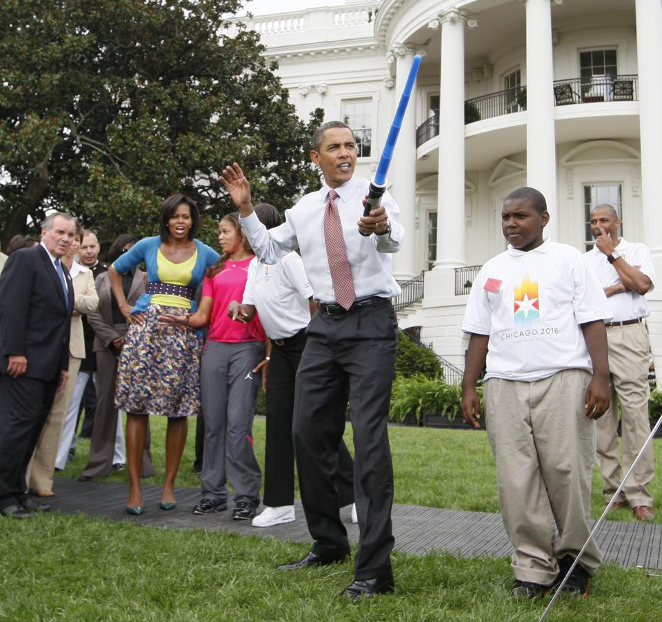 President Barack Obama uses a light saber as he watches a demonstration of fencing at an event supporting Chicago's 2016 host city Olympic bid, Wednesday, Sept. 16, 2009, on the South Lawn of the White House in Washington.