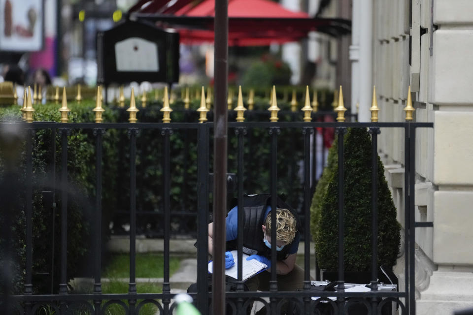 A police forensic officer inspects the entrance of the Harry Winston jewelry after a robbery in Paris, Saturday, May 18, 2024. French police investigators were hunting Saturday for armed robbers on motorbikes who hit a jewelry store on one of Paris' poshest streets, and media reports said the target was the exclusive Harry Winston boutique, self-described "Jeweler to the Stars." (AP Photo/Thibault Camus)