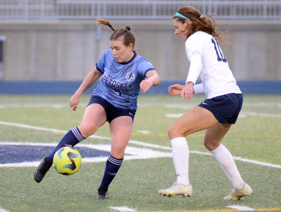 Petoskey's Lauren Cole works with the ball as Gaylord's Alivia Zaremba (right) runs in to defend.