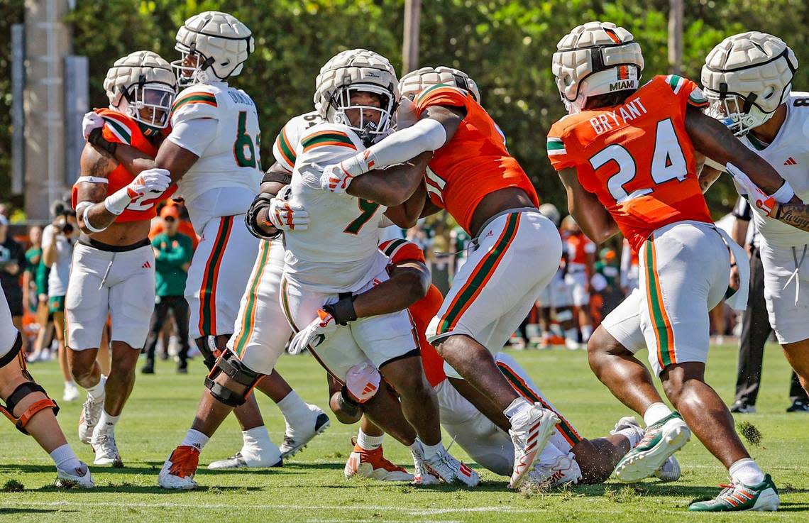 Miami Hurricanes Elijah Lofton (9) carries for yardage as Miami Hurricanes linebacker Wesley Bissainthe (31) and defensive lineman Anthony Campbell (93) make the stop during the Canes spring football game at the University of Miami’s Cobb Stadium in Coral Gables, Florida on Saturday, April 13, 2024.