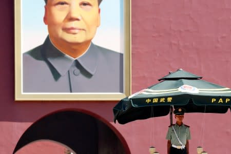 FILE PHOTO: A paramilitary policeman keeps watch underneath the portrait of former Chinese Chairman Mao Zedong in Beijing's Tiananmen Square