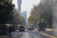 A demonstrator gestures toward riot police vehicles during a protest calling for changes in the education system in Santiago, Chile April 11, 2017. REUTERS/Ivan Alvarado