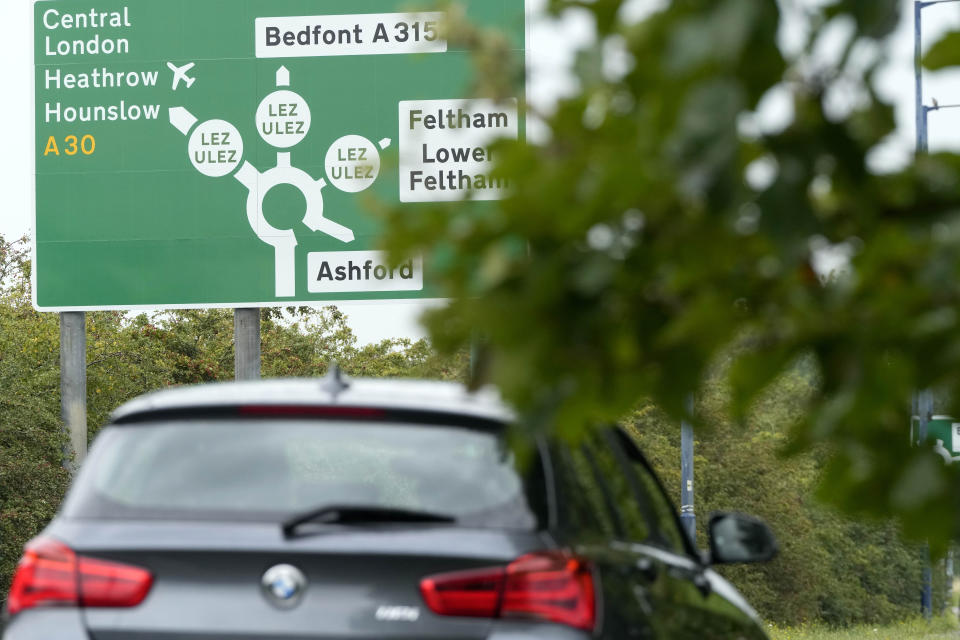 A car passes a road sign near a roundabout with leaving roads into the Ultra Low Emission Zone (ULEZ) in London, Thursday, Aug. 24, 2023. London’s traffic cameras are under attack. Police say hundreds of license plate-reading cameras have been damaged, disconnected or stolen by opponents of an anti-pollution charge on older vehicles that comes into force across the metropolis on Tuesday. The vandalism is a sign of how high emotions are running over the Ultra Low Emission Zone. (AP Photo/Frank Augstein)