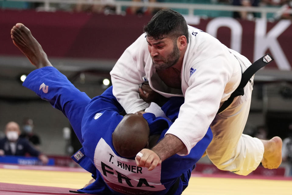 Or Sasson of Israel, top, and Teddy Riner of France compete during their men's +100kg elimination round judo match at the 2020 Summer Olympics, Friday, July 30, 2021, in Tokyo, Japan. (AP Photo/Vincent Thian)