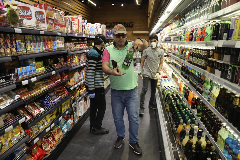 A man shops at a grocery in Bamland shopping mall, in Western Tehran, Iran, Sunday, March 15, 2020. Many people in Tehran shrugged off warnings over the new coronavirus as authorities complained that most people in the capital are not treating the crisis seriously enough. (AP Photo/Vahid Salemi)