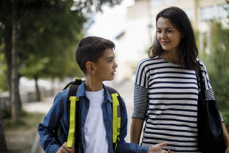 Mother and teenage boy going home from school