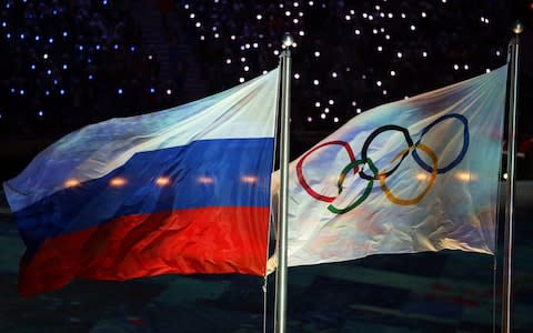 A file picture dated 23 February 2014 of the Olympic flag (R) and the Russian flag (L) during the Closing Ceremony of the Sochi 2014 Olympic Games in the Fisht Olympic Stadium in Sochi, Russia. Athletics ruling body IAAF on 13 November 2015 provisionally suspended Russian from its federation in a move barring it from international track and field events. The suspension is for an indefinite period and could include next year's Olympics in Rio de Janeiro - Credit: EPA