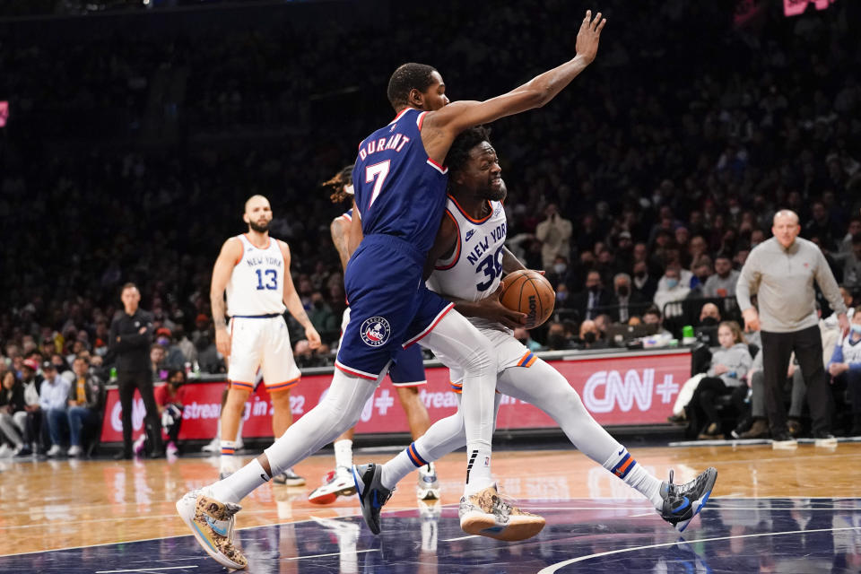 New York Knicks forward Julius Randle (30) drives against Brooklyn Nets forward Kevin Durant (7) during the first half of an NBA basketball game, Tuesday, Nov. 30, 2021, in New York. (AP Photo/Mary Altaffer)