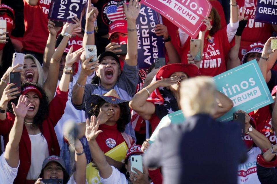 Donald Trump acknowledges the cheering crowd behind him at a campaign rally in Goodyear, Arizona, on 28 October.