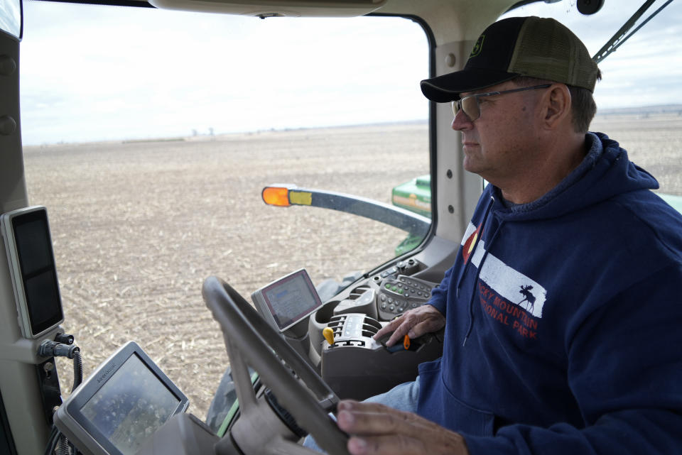 Don Schneider drives a tractor to plant alfalfa and oats on his property Friday, April 29, 2022, in Ovid, Colo. Schneider and his neighbors take surplus South Platte water in winter to augment the wells they use to irrigate their crops in summer. (AP Photo/Brittany Peterson)