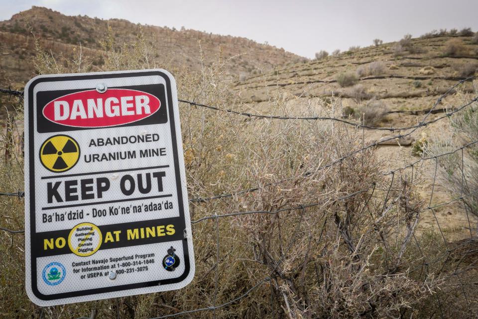 A warning sign affixed to a barbed wire fence looms outside the Church Rock uranium mine near the Navajo community at Red Water Pond Road, about 10 miles east of Gallup, New Mexico.