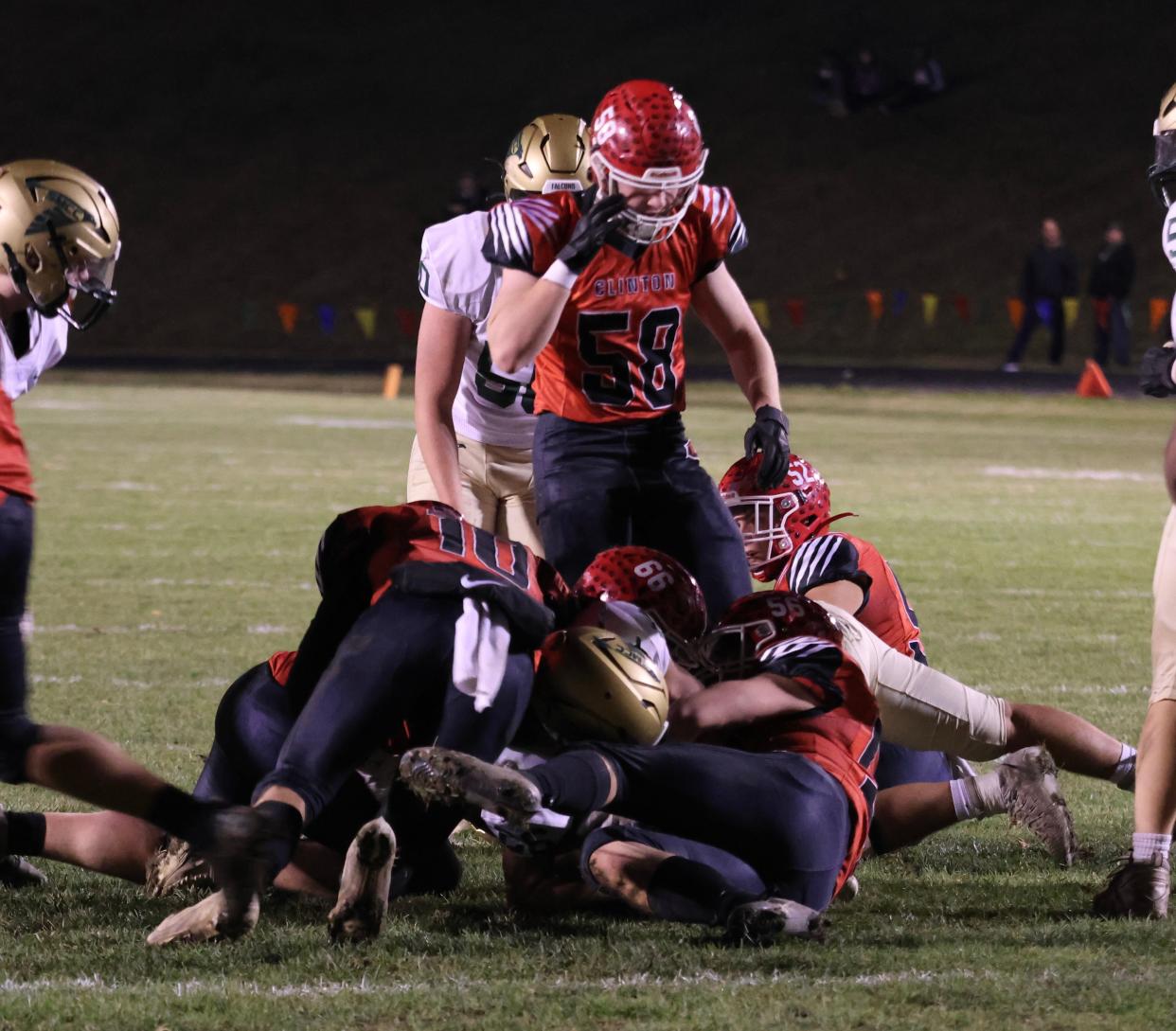Clinton's Teddy Pizio stands above the pile after the Redwolves defense makes a stop against Monroe St. Mary Catholic Central in the Division 7 district championship game.