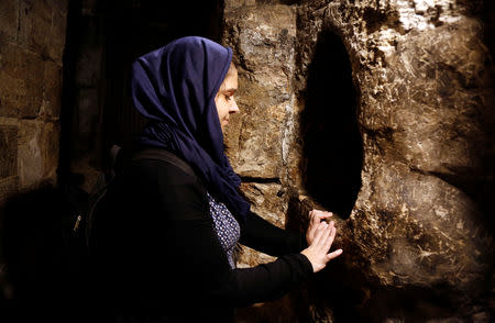 A tourist prays in the Church of the Nativity in Bethlehem, in the occupied West Bank, December 10, 2018. REUTERS/Raneen Sawafta