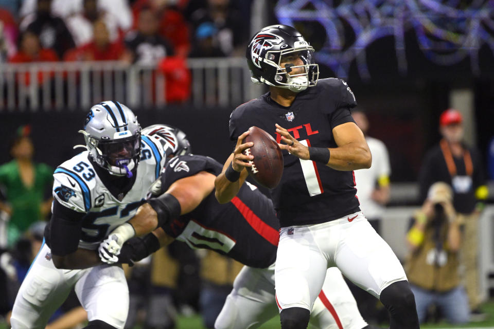 Atlanta Falcons quarterback Marcus Mariota (1) throws as Carolina Panthers defensive end Brian Burns (53) defends during the first half of an NFL football game Sunday, Oct. 30, 2022, in Atlanta. (AP Photo/John Amis)