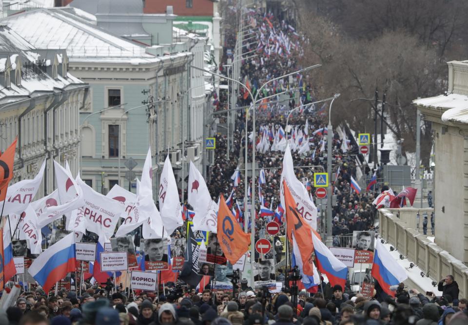Demonstrators, with flags of different opposition movements, march in memory of opposition leader Boris Nemtsov in Moscow, Russia, Sunday, Feb. 24, 2019. Thousands of Russians took to the streets of downtown Moscow to mark four years since Nemtsov was gunned down outside the Kremlin. (AP Photo/Pavel Golovkin)