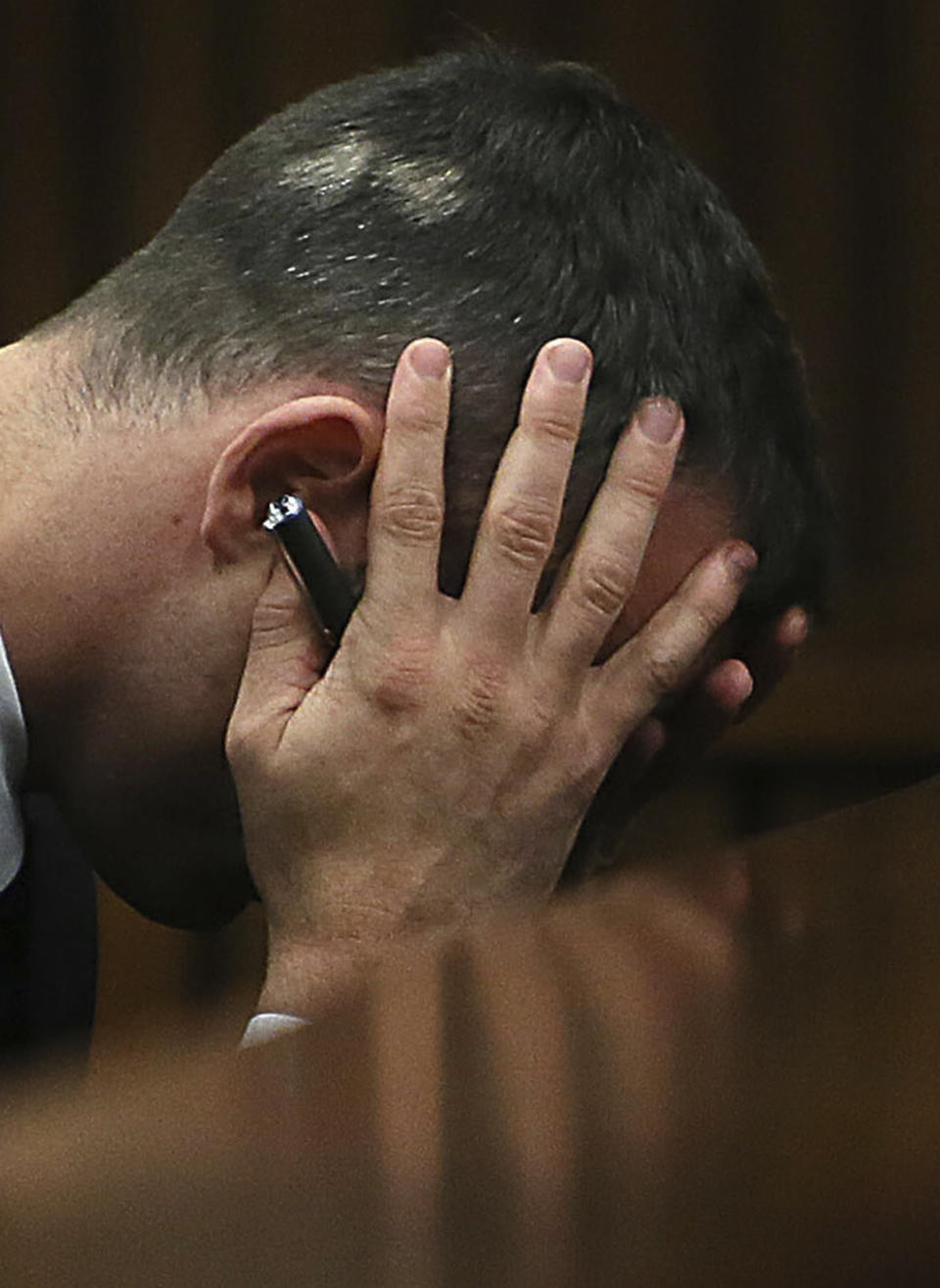 FILE — Oscar Pistorius holds his head in his hands as he listens to evidence being given in court in Pretoria, South Africa, Tuesday, April 15, 2014 after questioning by state prosecutor Gerrie Nel, had earlier finished. Pistorius shot his girlfriend Reeva Steenkamp more than a decade ago in a Valentine's Day killing that jolted the world and shattered the image of a sports superstar.(AP Photo/Alon Skuy, Pool, File)