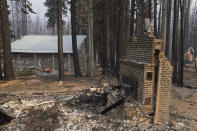 A cabin partially covered in fire-resistant material stands next to properties destroyed in the Caldor Fire in Twin Bridges, Calif., Thursday, Sept. 2, 2021. Better weather on Thursday helped the battle against a huge California forest fire threatening communities around Lake Tahoe, but commanders warned firefighters to keep their guard up against continuing dangers. (AP Photo/Jae C. Hong)