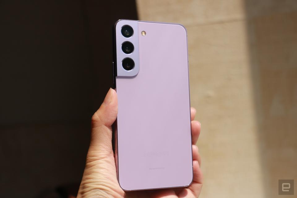 <p>An off angle shot of the side of the Bora Purple Galaxy S22 held up in mid-air in the sun, with its back facing the camera.</p>
