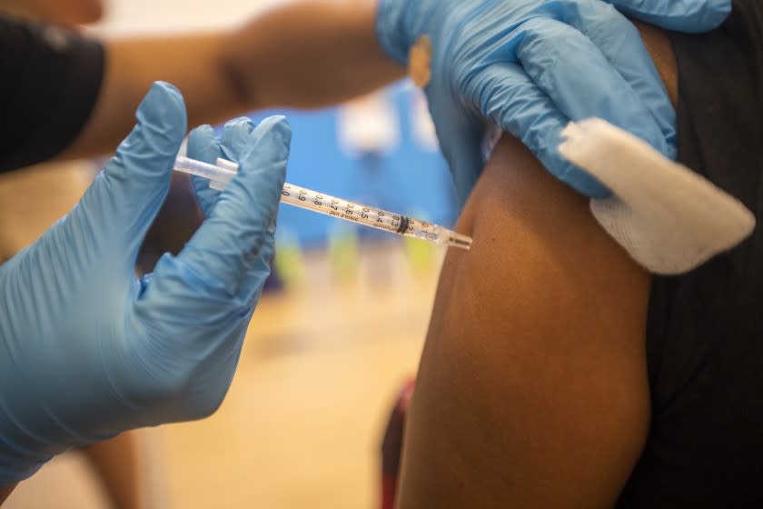 WILMINGTON, CA - JULY 27: Nursing student Joanna Aguilar, left, is giving a vaccination to Maria Isabel Cruz at a vaccination clinic at the Providence Wellness and Activity Center on Tuesday, July 27, 2021 in Wilmington, CA. Escalating COVID-19 cases are threatening a new surge in Southern California . Providence is holding three-day COVID-19 vaccine clinic in Wilmington for people 12 years old and up Tuesday, Wednesday, Thursday, July 27-29. (Francine Orr / Los Angeles Times)