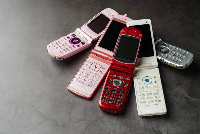 Colorful flip phones all gathered on a table