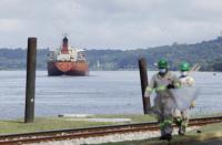 A cargo ship navigates through Panama Canal waters in Gamboa, Panama, Wednesday, June 17, 2020. The Panama Canal began to feel the first adverse effects of the coronavirus pandemic on its business after registering a drop in its ship transits, while applying rigorous measures to prevent further contagion among its workers. (AP Photo/Arnulfo Franco)