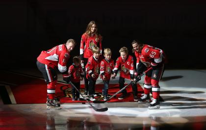 Alfredsson, with his wife and four sons, takes the ceremonial faceoff with protege Erik Karlsson. (Getty)