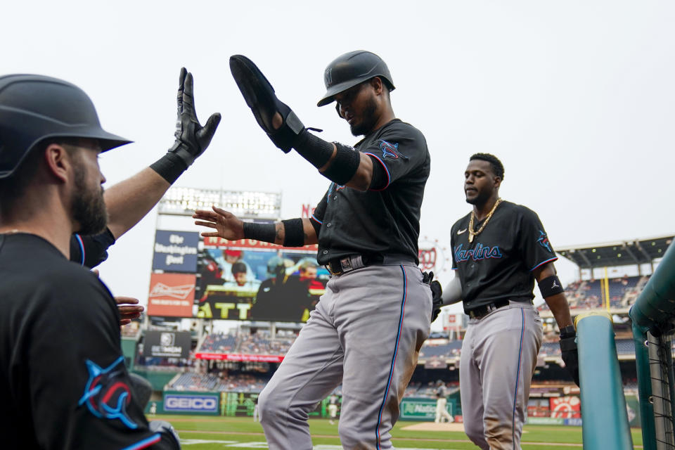Miami Marlins' Luis Arraez, center, and Jorge Soler, right, return to the dugout after scoring during the first inning of the team's baseball game against the Washington Nationals at Nationals Park, Friday, June 16, 2023, in Washington. (AP Photo/Alex Brandon)