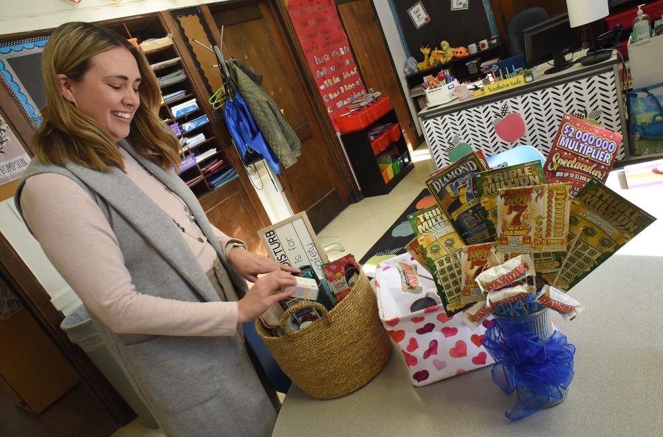 Dundee Elementary School literacy coach Emily Thompson arranges the basket that she, literacy coach Carrie Sampson and special education teacher Kristi Hawkins created for a raffle at a spaghetti dinner fundraiser Tuesday, Feb. 7, at The Little Brown Jug. Proceeds from the fundraiser will be donated to fellow teacher Jenny Dolezal, who is fighting breast cancer. Other baskets pictured are lottery tickets from the Dundee school district's central office and a heart basket from the first grade class.