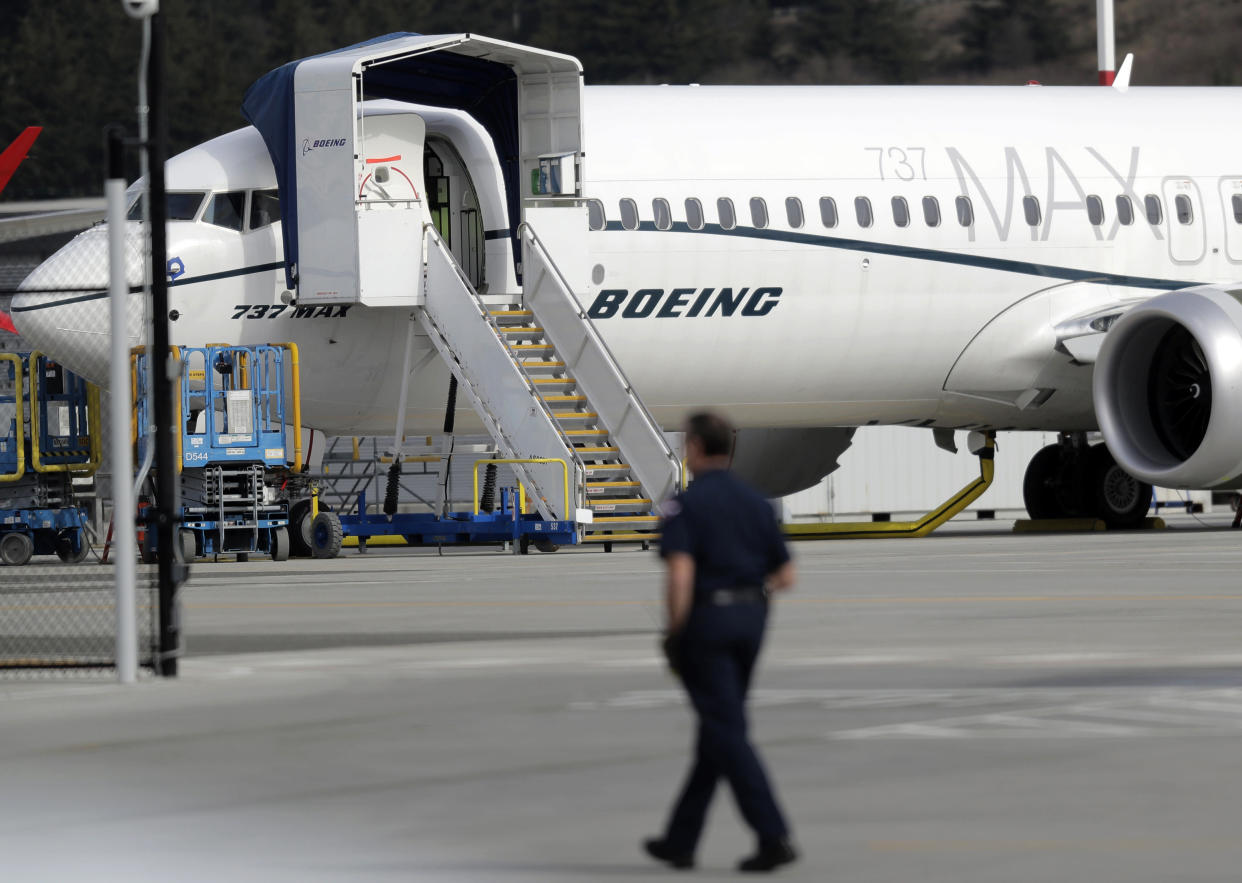 A worker walks next to a Boeing 737 MAX 8 airplane parked at Boeing Field, Thursday, March 14, 2019, in Seattle. The fatal crash Sunday of a 737 MAX 8 operated by Ethiopian Airlines was the second fatal flight for a Boeing 737 Max 8 in less than six months, and more than 40 countries, including the U.S., have now grounded the planes or refused to let them into their airspace. (AP Photo/Ted S. Warren)