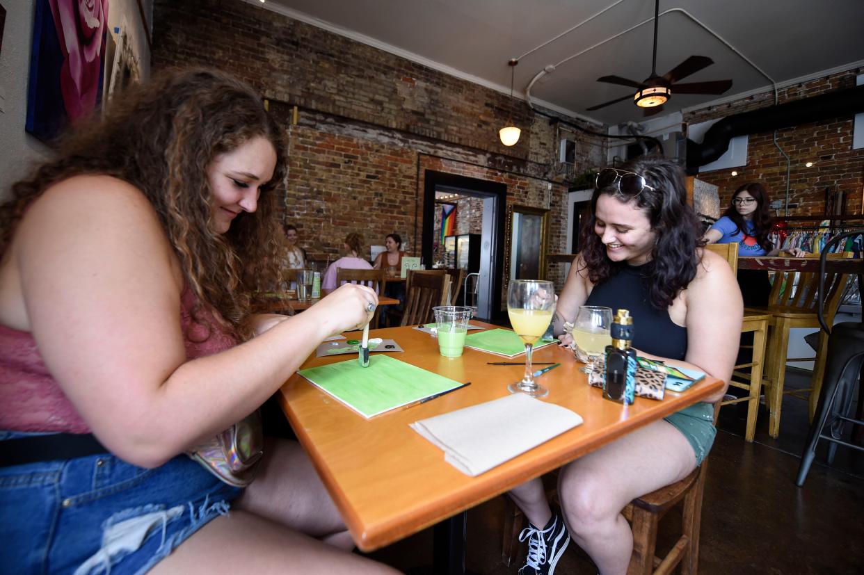 FILE - Madie Snyder (left) and Jazmyn Perdue (right) paint artwork during the Paint and Sip event hosted by Flutterby Studio at Bee's Knees on Friday, July 1, 2022. The business closed on Nov. 20.