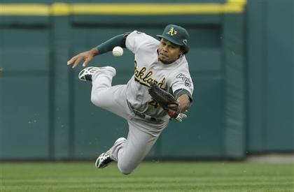 A's outfielder Coco Crisp bobbles a hit in the seventh inning of Game 2. (AP)