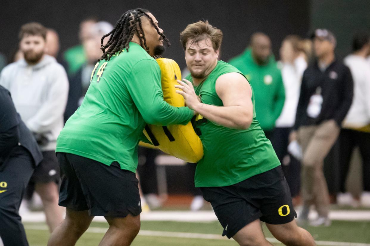 Oregon offensive linemen Steven Jones, left, and Jackson Powers-Johnson run drills during Oregon Pro Day Tuesday, March 12, 2024 at the Moshofsky Center in Eugene, Ore.