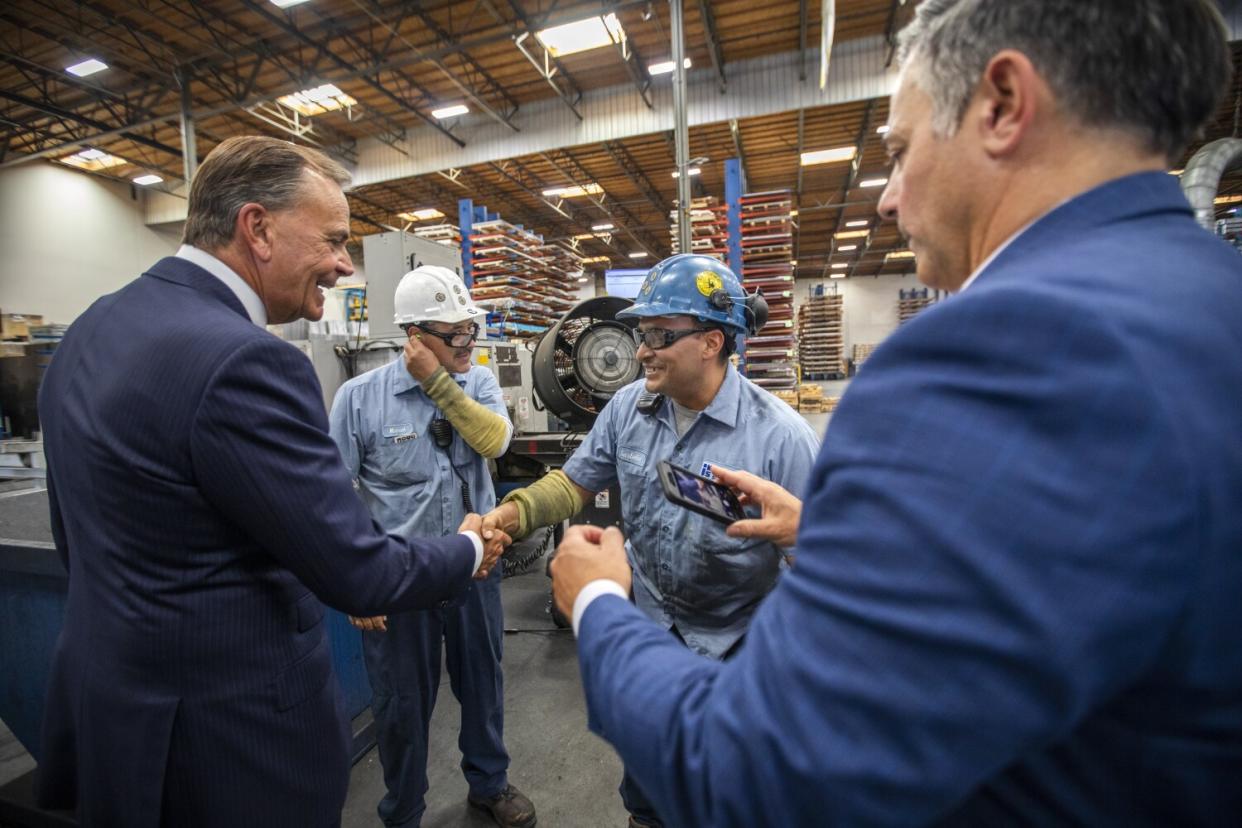 Rick Caruso talk with workers.