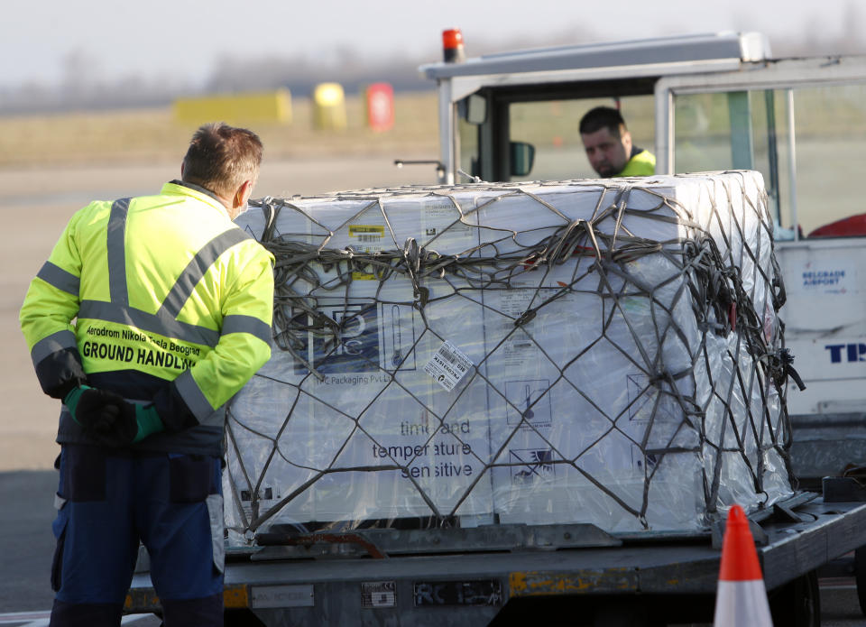 Workers unload boxes of the Astra Zeneca vaccine at the Belgrade Airport, Serbia, Sunday, Feb. 21, 2021. 150,000 doses of Astra Zeneca vaccines were delivered to Serbia. (AP Photo/Darko Vojinovic)