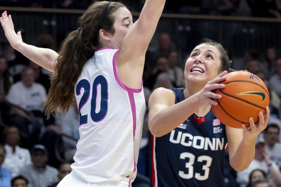 UConn guard Caroline Ducharme (33) goes to the basket past Villanova forward Maddy Siegrist (20) during the first half of an NCAA college basketball game, Saturday, Feb. 18, 2023, in Villanova, Pa. (AP Photo/Laurence Kesterson)