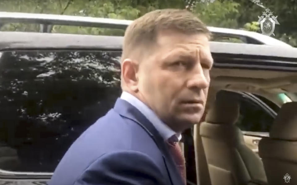 In this image distributed by Russian Investigative Committee, Sergei Furgal, the governor of the Khabarovsk region is escorted by Russian Federal Security Service (FSB, Soviet KGB successor) and Russian Investigative Committee agents in Khabarovsk, Russia, Thursday, July 9, 2020. Sergei Furgal, the governor of the Khabarovsk region along the border with China, was arrested in Khabarovsk and was flown to Moscow and has been arrested on charges of involvement in multiple murders. (The Investigative Committee of the Russian Federation via AP)