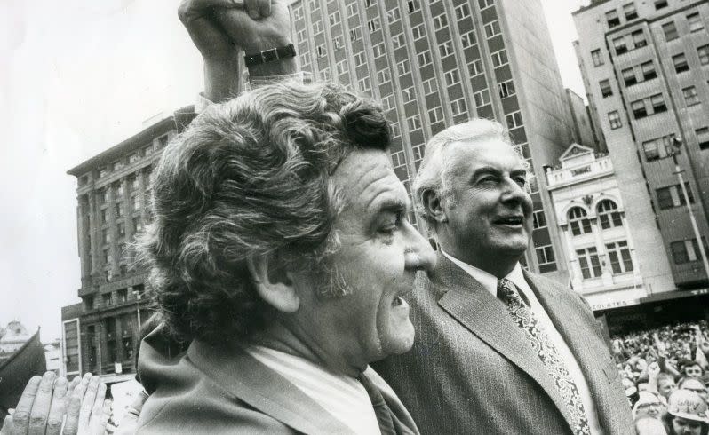 The Prime Minister Mr Gough Whitlam and the President of the ACTU and ALP, Mr Bob Hawke, link hands to acknowledge the crowd. October 20 1975. Source: Supplied