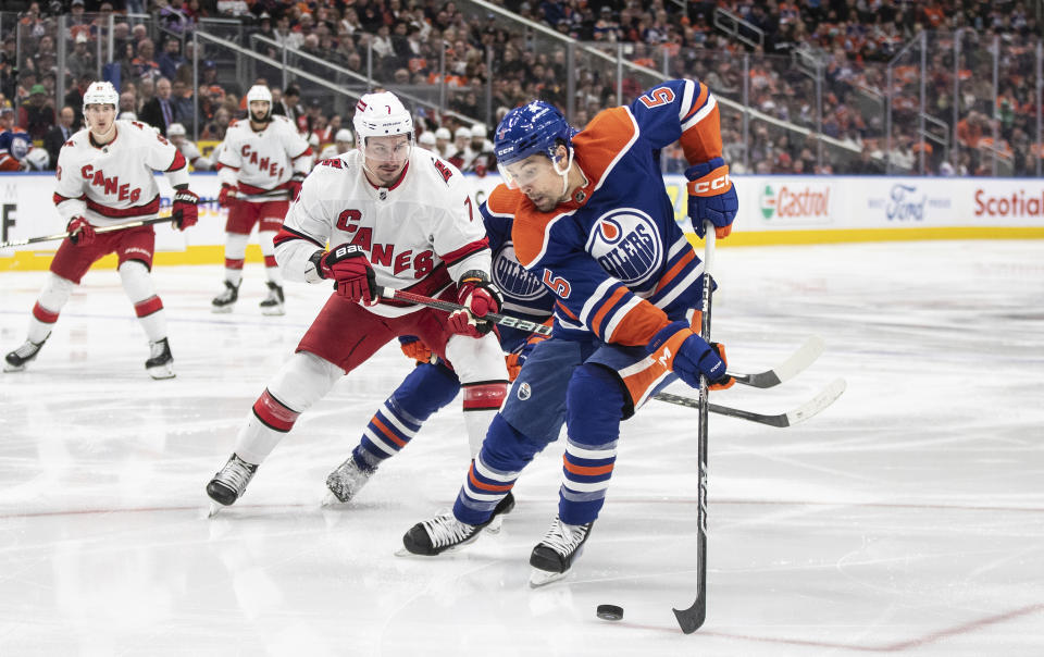 Carolina Hurricanes' Dimitri Orlov (7) and Edmonton Oilers' Cody Ceci (5) vie for the puck during the third period of an NHL hockey game Wednesday, Dec. 6, 2023, in Edmonton, Alberta. (Jason Franson/The Canadian Press via AP