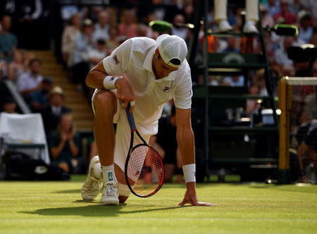 Tennis - Wimbledon - All England Lawn Tennis and Croquet Club, London, Britain - July 13, 2018 John Isner of the U.S. after falling during his semi final match against South Africa's Kevin Anderson REUTERS/Tony O'Brien