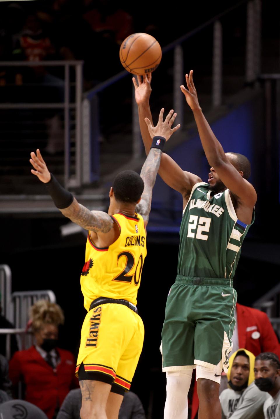 Bucks forward Khris Middleton, who had a game-high 34 points, attempts a three-pointer over Hawks forward John Collins during the second quarter Monday.