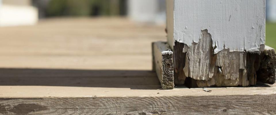 Detail of column post damage on home's front porch.