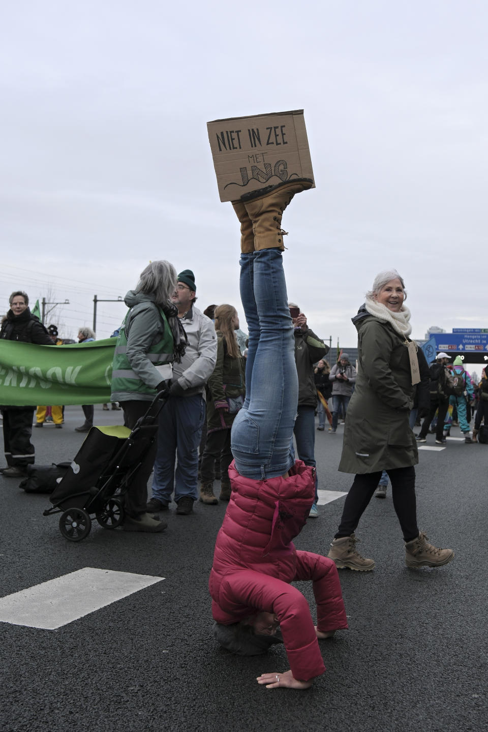 A protestor displays a sign with the words "Not doing business with ING" as climate activists block the main highway around Amsterdam near the former headquarters of a ING bank to protest its financing of fossil fuels, Saturday, Dec. 30, 2023. Protestors walked onto the road at midday, snarling traffic around the Dutch capital in the latest road blockade organized by the Dutch branch of Extinction Rebellion. (AP Photo/Patrick Post)