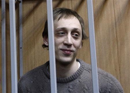 Dancer Pavel Dmitrichenko looks out from the defendant's holding cell during a hearing in Moscow in this October 22, 2013 file photo. REUTERS/Maxim Shemetov/Files