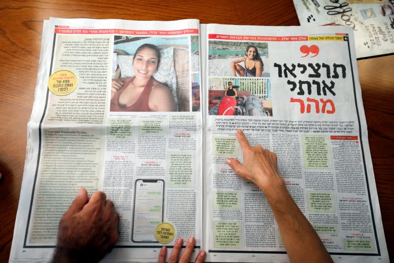 Israel, the uncle of Naama Issachar, and his wife look at a newspaper with an article about Naama at their home in Rehovot