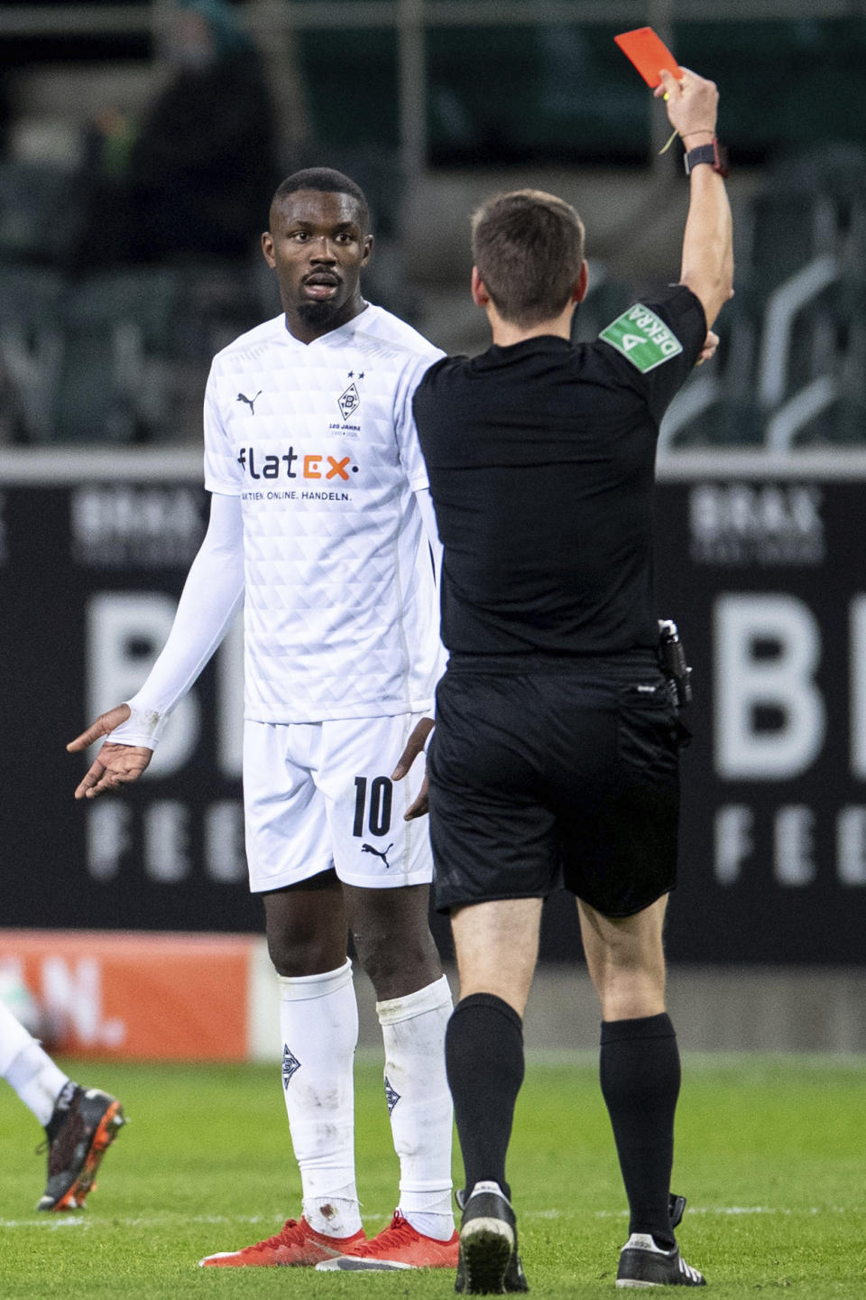 El árbitro Frank Willenborg muestra la tarjeta roja a Marcus Thuram, del Borussia Mönchengladbach, durante un partido ante el Hoffenheim, el sábado 19 de diciembre de 2020 (Marius Becker/dpa via AP)