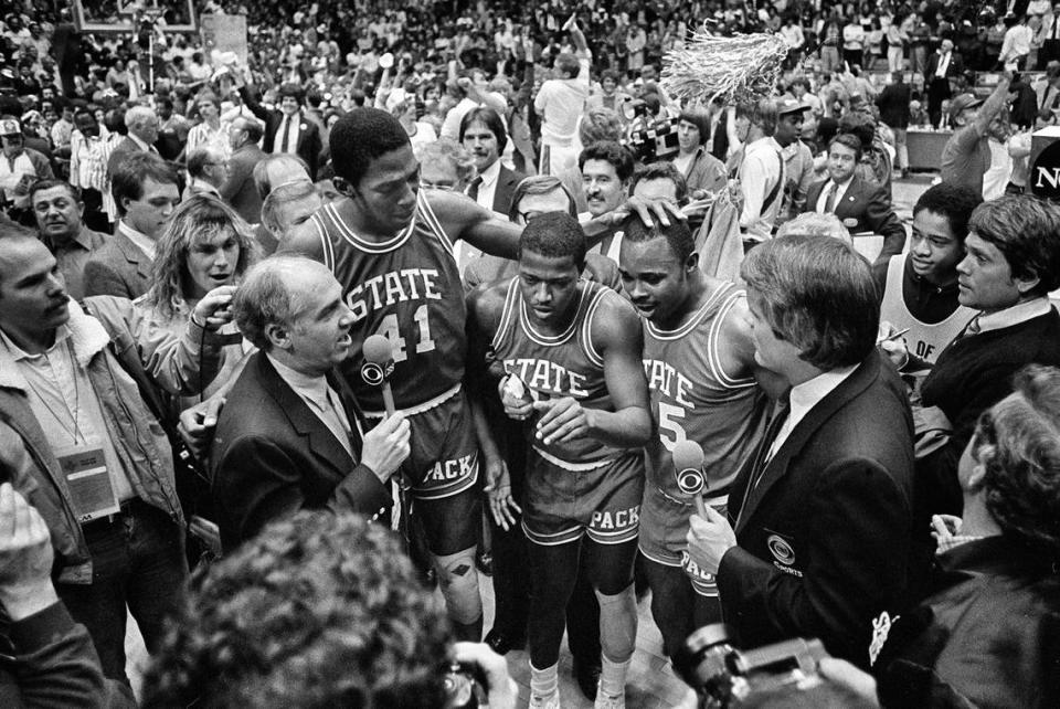 CBS announcer Billy Packer, left, interviews N.C. State seniors Thurl Bailey, Dereck Whittenburg, and Sidney Lowe after the Wolfpack won the National Championship on April 4, 1983. The Wolfpack won the game 54-52. Mike Sargent/News and Observer file photo